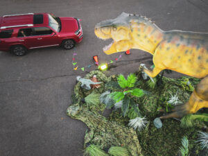 dinosaur looking at car