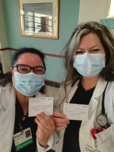 doctor and nurse display vaccine cards