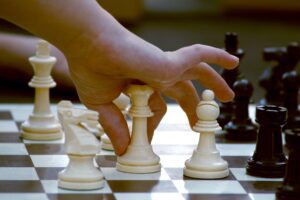 A child moving a piece on a Chess board