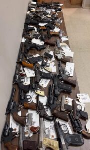 Dozens of hand guns on a table