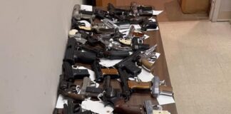 Dozens of hand guns on a table