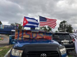 Cuban and American flags waving above a truck