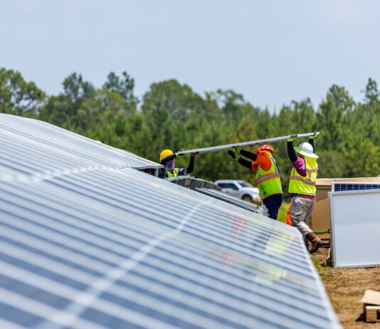working men installing solar panels