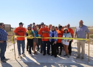 Commissioner Bergosh is joined by supporters of Beach Access #4 as he cuts the ceremonial ribbon