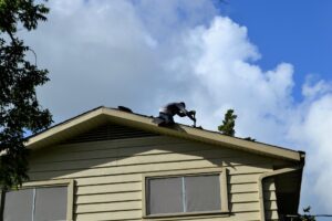 worker reroofing a house