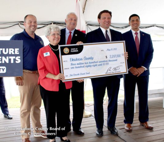 Governor DeSantis presenting check to Okaloosa County commissioners