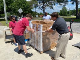 men unwrapping a crate of boxes