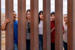 Family looking through border wall