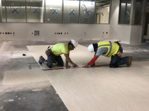 Workers installing flooring at the new Baptist Hospital