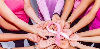 hands holding a pink ribbon