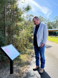 A man reads an informational plaque at the park