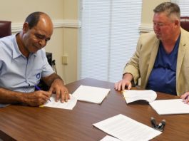 Two men signing an agreement