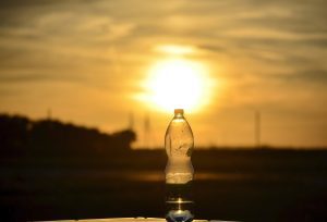 hot sun behind a bottle of water
