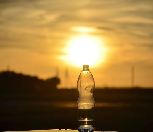hot sun behind a bottle of water