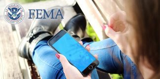 Cellphone in hand behind FEMA logo