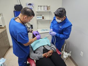 Dentists Gabriel Hernandez and assistant Ronnie Gonzales treat a patient