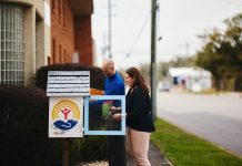 Two people stocking a community little library