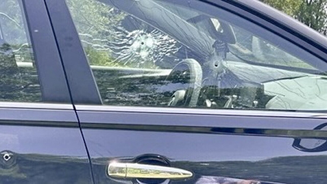 Car with bullet holes in windows and door