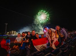 Fans watching fireworks while displaying the Mexican flag