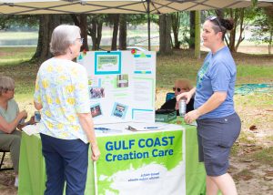 People talking at a tent and table display