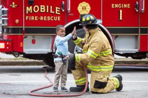 Firefighter and child high-fiving