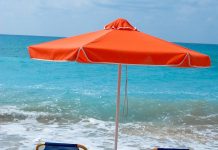 Beach chairs and umbrella on wet sand