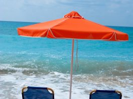 Beach chairs and umbrella on wet sand