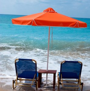 Beach chairs and umbrella on wet sand