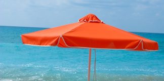 Beach chairs and umbrella on wet sand