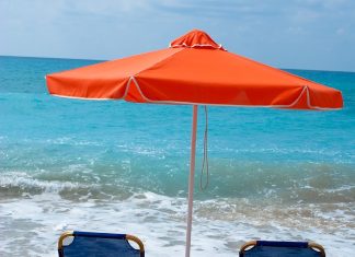 Beach chairs and umbrella on wet sand