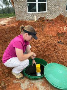 Person collecting a water sample from the ground