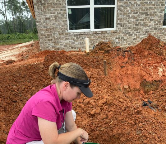 Person collecting a water sample from the ground