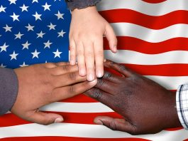 multi ethnic hands touching US flag