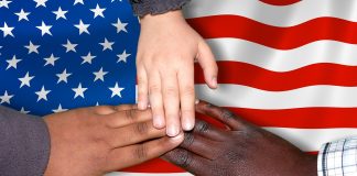 multi ethnic hands touching US flag