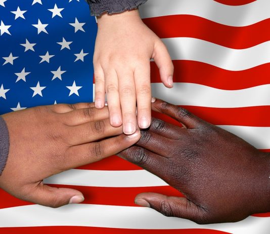 multi ethnic hands touching US flag