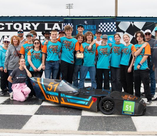 Students standing in a group in front of their speed vehicle