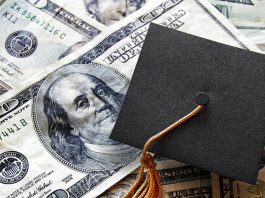 Graduation cap laying on top of US currency