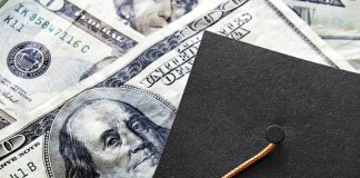 Graduation cap laying on top of US currency
