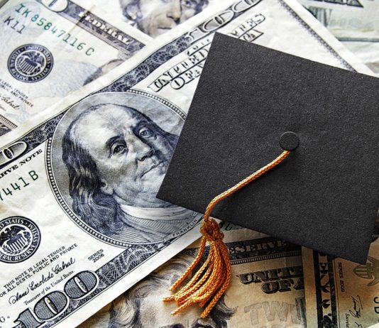 Graduation cap laying on top of US currency