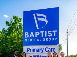 People standing next to the Baptist medical facility sign