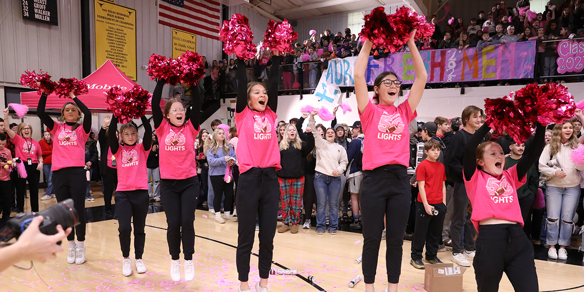 Cheerleaders cheering at a school pep rally