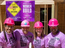 Four women wearing pink hardhats