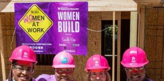 Four women wearing pink hardhats